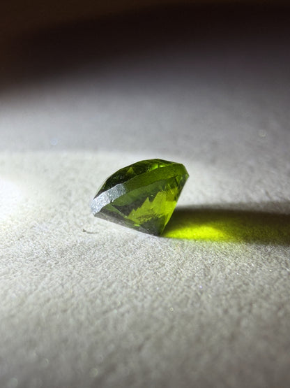 Green gemstone on a textured white surface