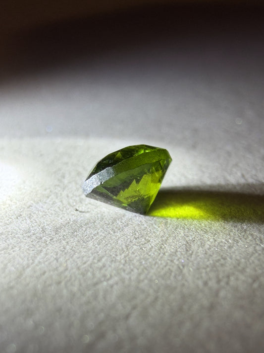 Green gemstone on a textured white surface