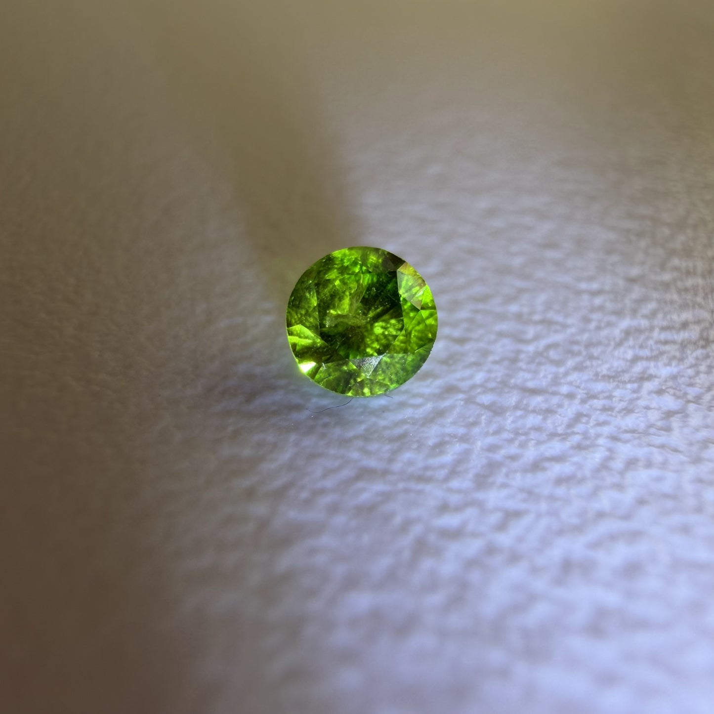 Green gemstone on a textured beige background