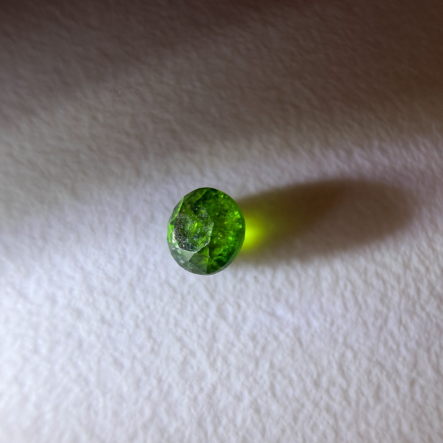 Green gemstone on a white fabric background