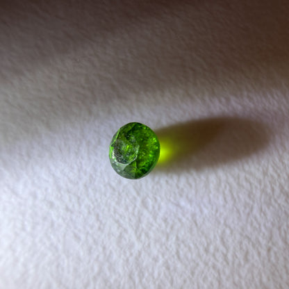 Green gemstone on a white fabric background