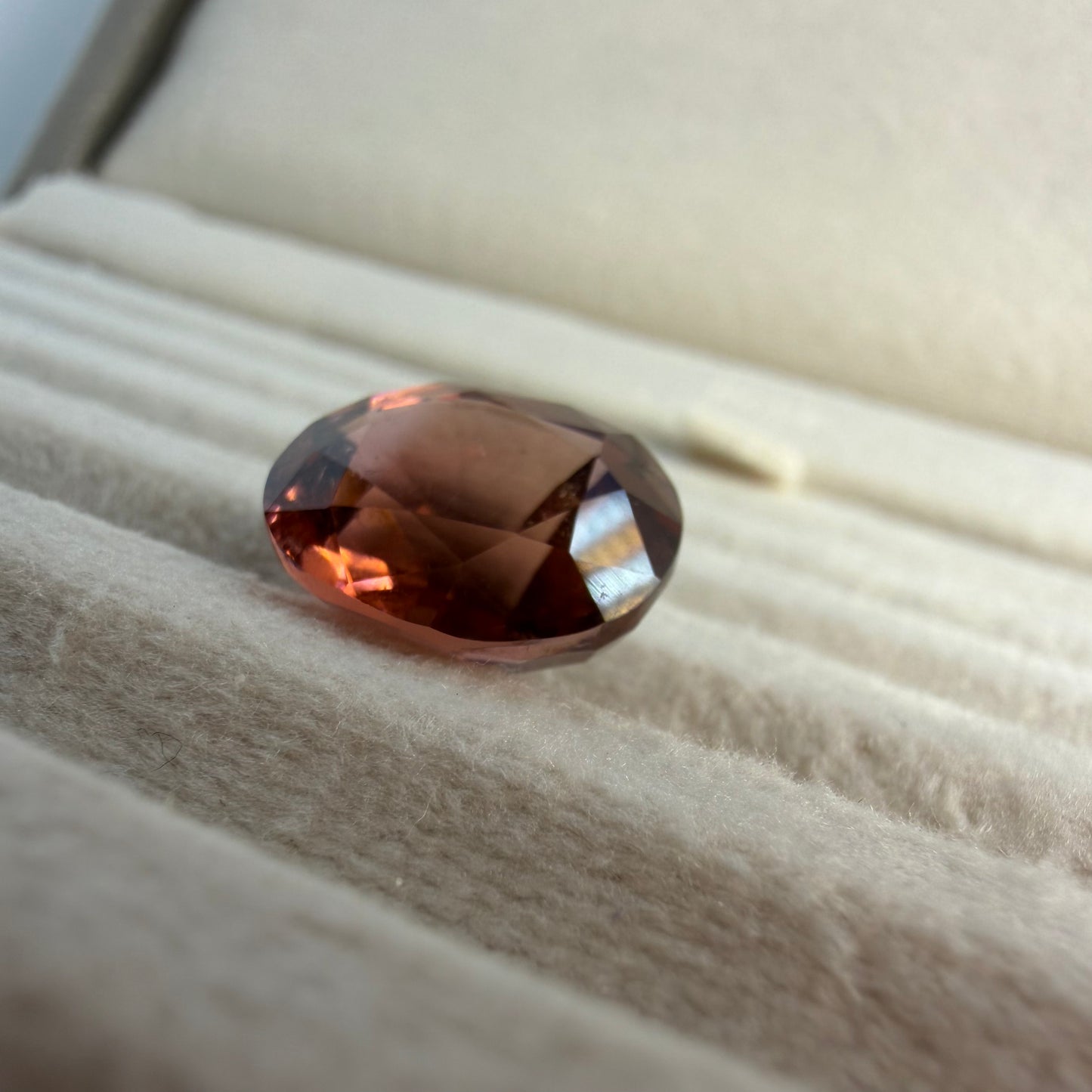 Brown gemstone on a textured beige surface