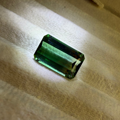 Green gemstone on a textured beige surface