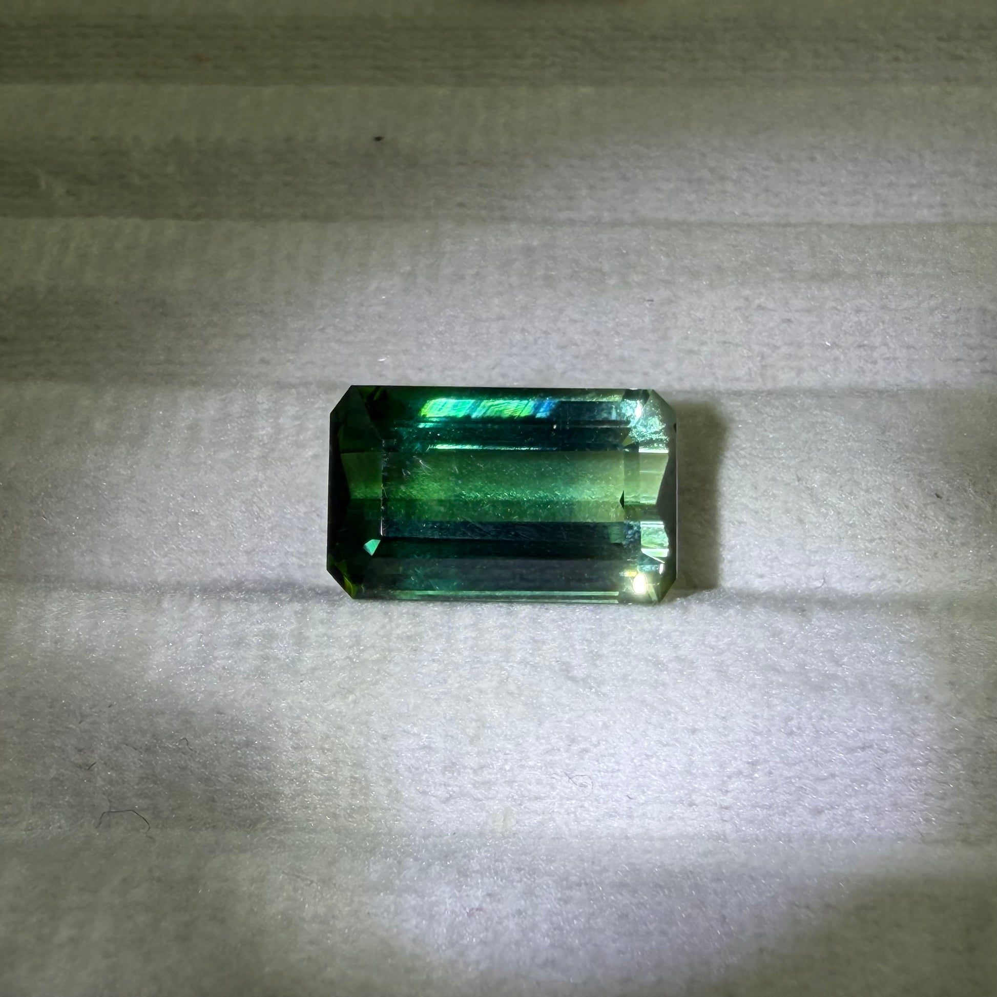 Green gemstone on a textured gray background