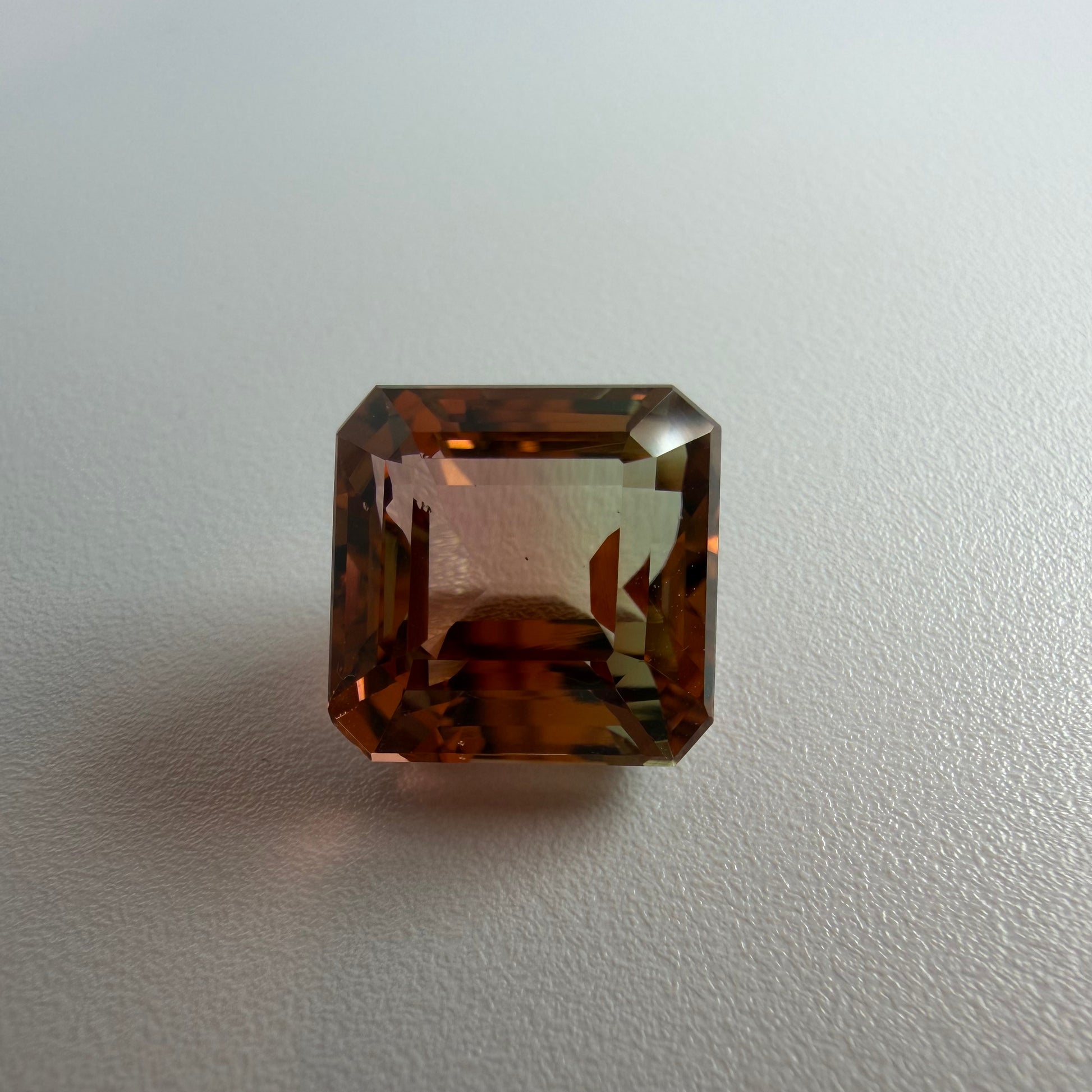 Octagonal brown gemstone on a light gray background
