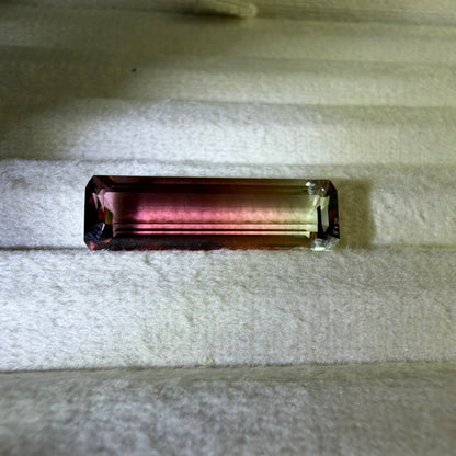 Multicolored gemstone on a textured white surface