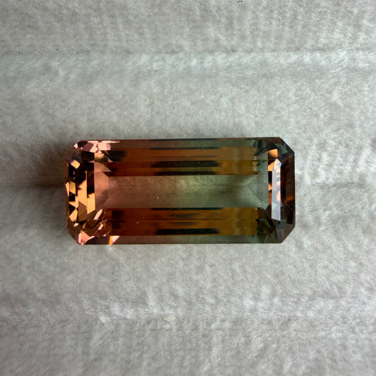 Rectangular brown gemstone on a textured gray background