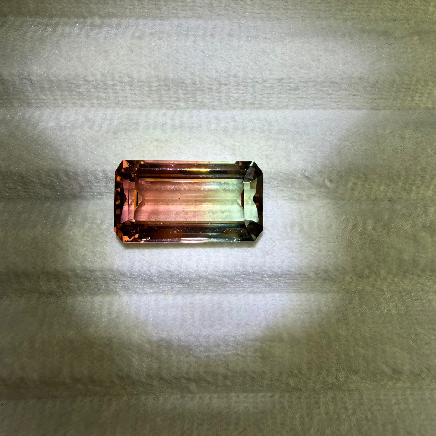 Multicolored gemstone on a textured fabric background